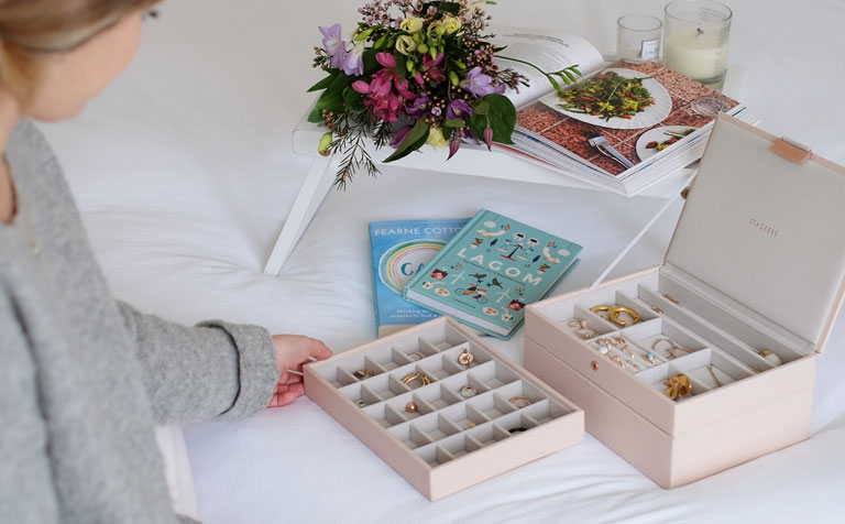 Woman sitting on bed looking at Stackers Jewellery Box