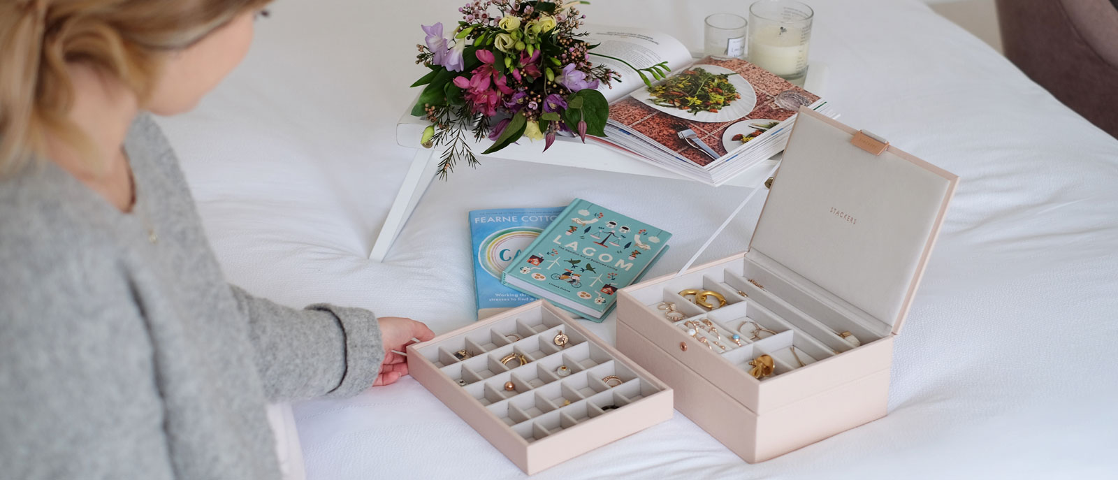 Woman sitting on bed looking at Stackers Jewellery Box